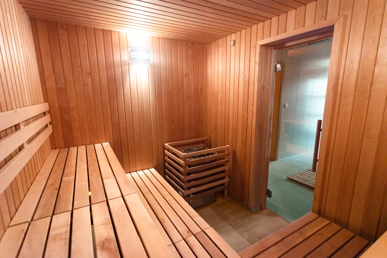 Finská sauna s dřevěnými lavicemi a kamny